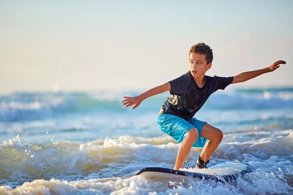 Опытный подросток катается на доске для серфинга и балансирует длинное волнистое море . — стоковое фото