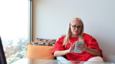 İnternetten alışveriş yapan bir kadın evinde akıllı telefon kullanıyor. ecommerce, online alışveriş ve mağaza konsepti