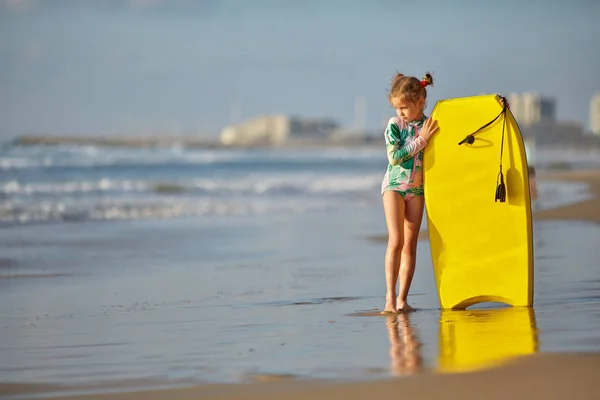 Отдых на пляже. Close Up Of Healthy Happy Beautiful little girl in a swimsuit with Surfboard — стоковое фото