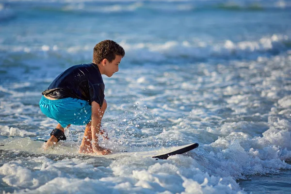 熟练的青少年驾驶冲浪板，在波涛汹涌的大海中保持平衡 — 图库照片