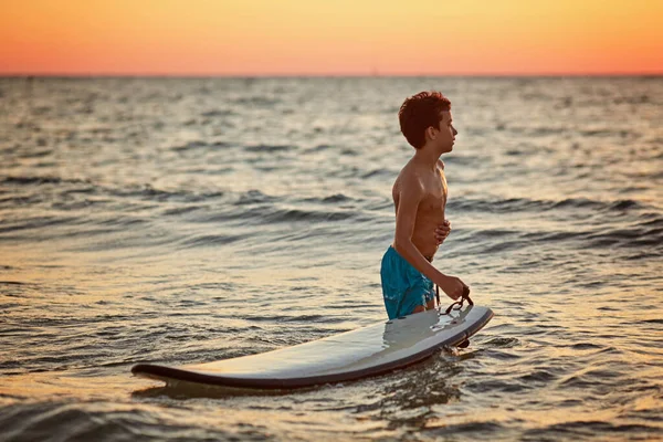 Surfer läuft mit Surfbrett bei Sonnenuntergang in Island — Stockfoto