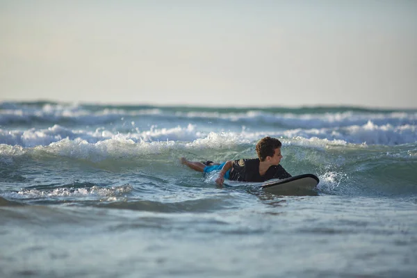 A kisfiú szörfözik egy szörfdeszkán az Indiai-óceánon. — Stock Fotó