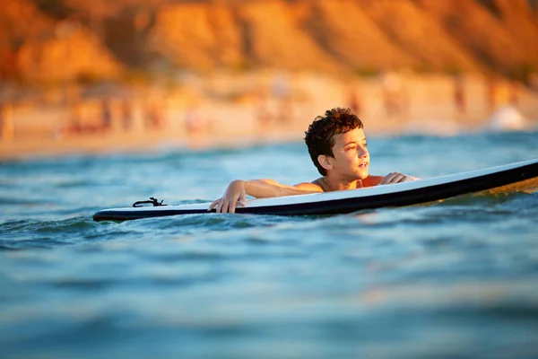 Молодой серфер, счастливый мальчик в океане на доске для серфинга — стоковое фото