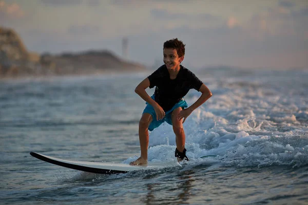 Junge lernen, wie man surft. ein junger Surfer blickt auf den Ozean — Stockfoto
