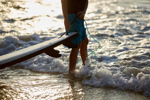 Tabla de surf en la mano de los surfistas imagen de cerca con vista al mar olas . —  Fotos de Stock