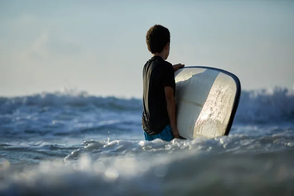 Young caucasian man surfs the ocean wave