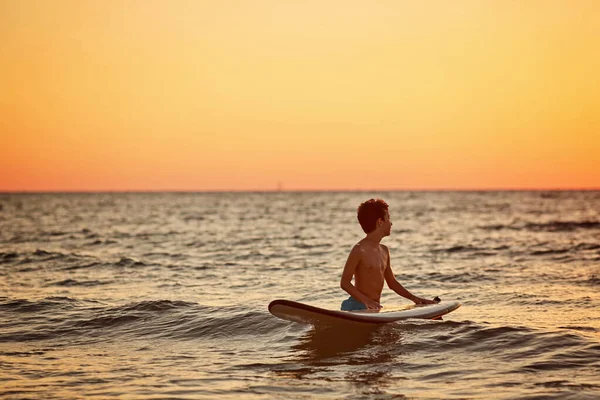 Surf infantil en la playa tropical. Vacaciones familiares de verano en Asia. Los niños nadan en el agua del océano —  Fotos de Stock