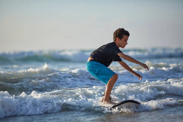 小男孩在印度洋的冲浪板上冲浪. — 图库照片