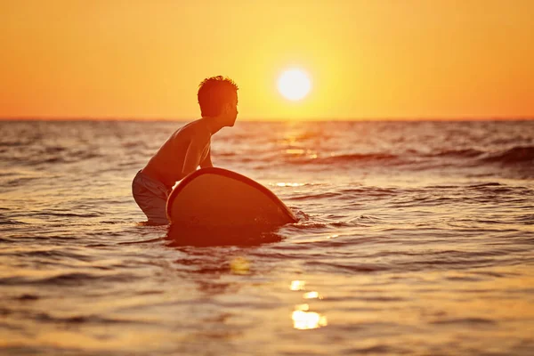 Ein Surfer mit seinem Surfbrett am Strand — Stockfoto