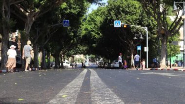 Tel Aviv, İsrail - 9 Ekim 2019: Kimliği belirsiz insanlar güneşli bir sabahta boş bir yolda yürüyor