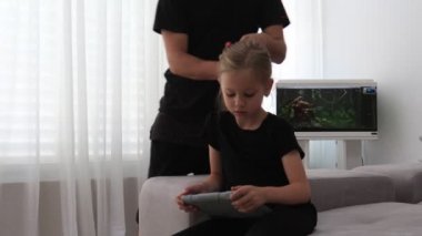 Babam kanepede otururken kızların saçları tarak. Baba ve kızı birlikte vakit