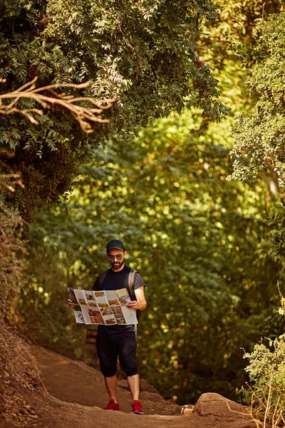 バックパック付きハイカーは荒野の方向を見つけるために地図をチェックします。ナハル・ハーモンハーモン・ストリーム — ストック写真
