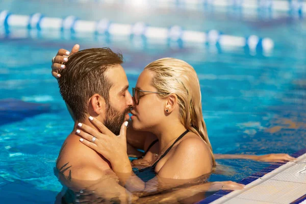 Couple kissing in swimming pool on resort