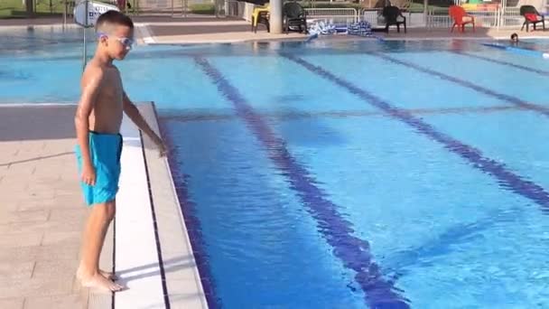 Glücklicher kleiner Junge springt in goldenen Stunden in Zeitlupe ins Pool-Wasser. — Stockvideo