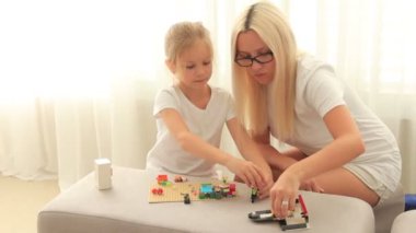 Anne kızıyla inşaatçılık oynuyor.