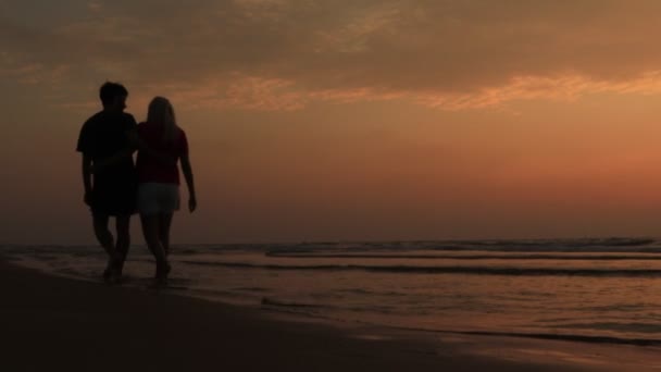 Beach solnedgång par promenader romantisk på smekmånad förälskad. Soluppgång romantik unga par i eleganta casual kläder promenader tillsammans njuta av semester resor — Stockvideo