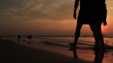 Baba ve oğul gün batımında sahilde. Mutlu genç aile sahilde eğleniyor. Gün batımında koş ve atla.