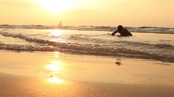 Silhouette der Jungen stehen und spielen mit dem Sonnenuntergang — Stockvideo