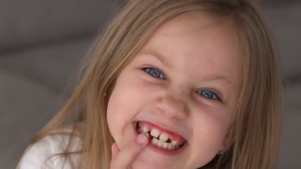 Retrato de una linda chica sonriente sin dientes. De cerca. — Vídeos de Stock