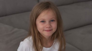 6 yaşındaki kız dalga geçiyor ve yüzünü buruşturuyor.