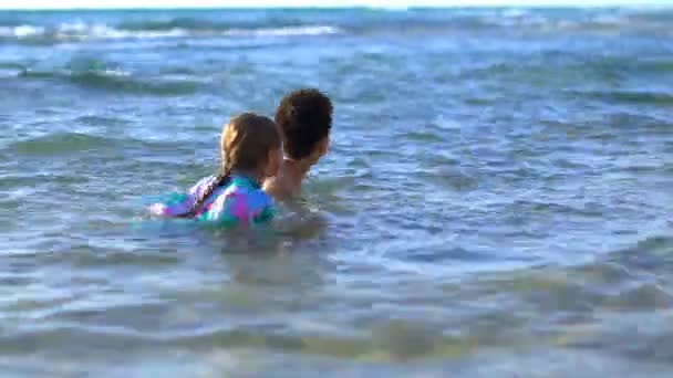 Menino e menina feliz jogar na água do mar no verão em um dia ensolarado quente. As crianças brincam à beira-mar — Vídeo de Stock