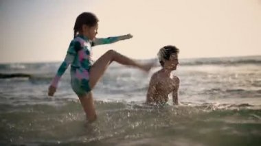 Mutlu Çocuklar, neşeli küçük oğlan ve suda oynayan kız. Yaz tatili. Yaz eğlencesi. Yüksek kaliteli FullHD görüntüler