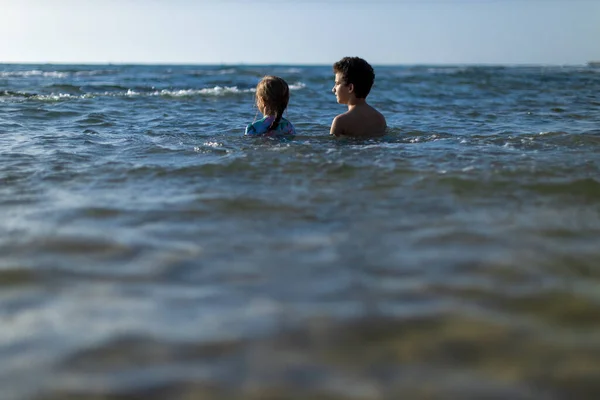 Testvér és nővér a strandon naplementekor — Stock Fotó