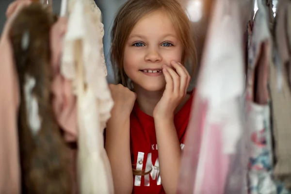 Foco suave de uma criança de 5-6 anos Escolhendo seus próprios vestidos de Kids Cloth Rack na loja de roupas — Fotografia de Stock