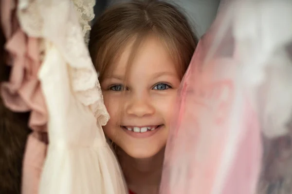 Vue rapprochée de la fille debout entre les vêtements — Photo