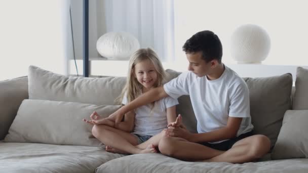 Irmão ensina irmã meditação, descansar no sofá meditar aliviar emoções negativas no fim de semana em casa — Vídeo de Stock