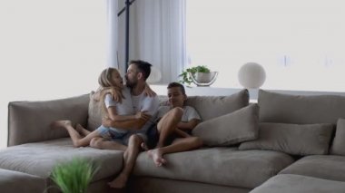 Vesikalıklı, genç, bekar bir ebeveyn. Evinde küçük, neşeli bir kızı kucaklıyor.