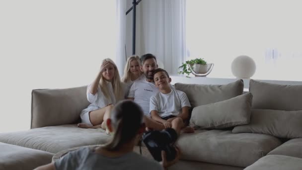 Professionele fotograaf maakt foto 's van vrolijke familie op professionele camera in de woonkamer — Stockvideo