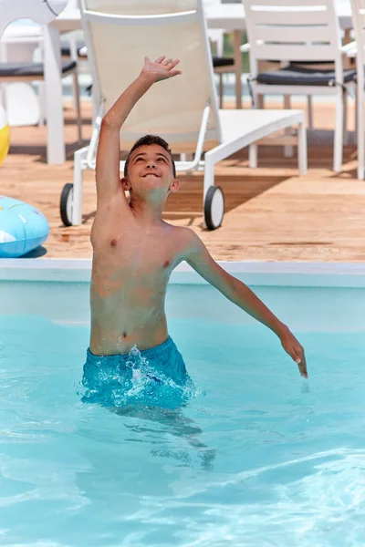 Jovem menino jogar vôlei em pequena piscina — Fotografia de Stock