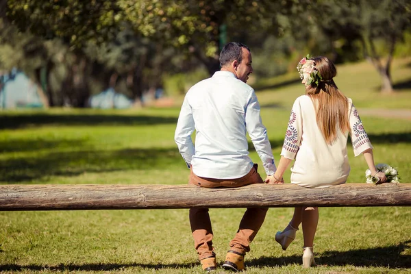 Pareja está abrazando y sentado cerca en el parque — Foto de Stock