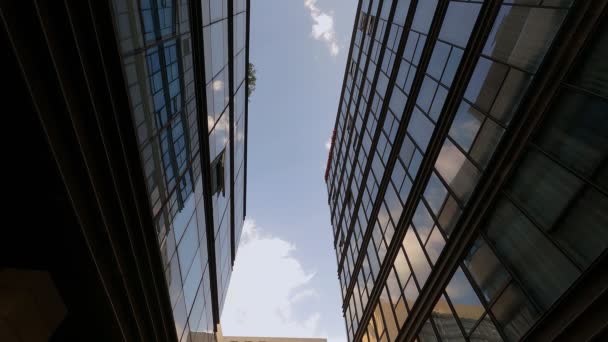 Viento ligero impulsa grandes nubes blancas a través del cielo azul reflejado en la construcción de oficinas locales ventanas panorámicas lapso de tiempo — Vídeos de Stock