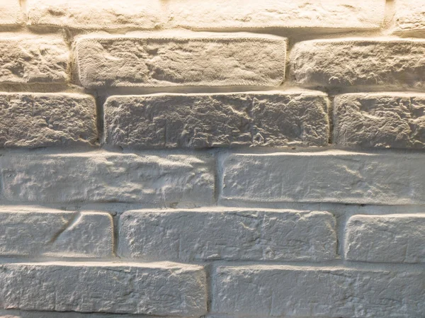 white rough brick wall illuminated from above