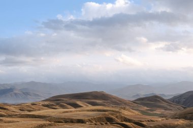 düz hills yüksek ağaçlar olmadan bir bulutlu gökyüzü altında dağlarda