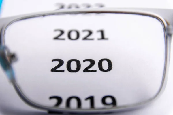 白纸上最近几年的清单。 专注于2020年。 透过眼镜观看复制空间 — 图库照片