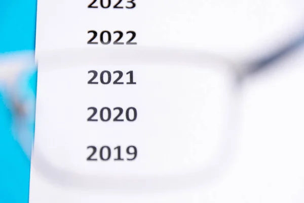 Lista de los últimos años sobre el papel blanco. Concéntrate en 2020. Ver a través de gafas Copiar espacio — Foto de Stock