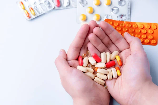 Pílulas e cápsulas na mão sobre fundo branco — Fotografia de Stock