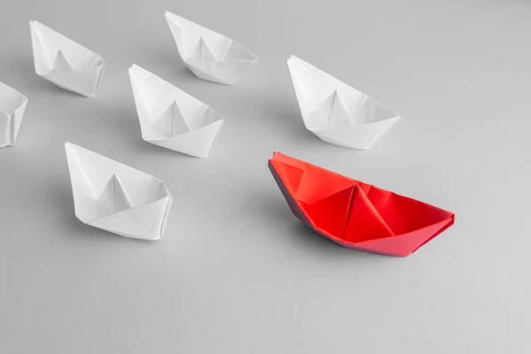 Conceito de liderança usando navio de papel vermelho entre brancos. De cima . Fotos De Bancos De Imagens Sem Royalties
