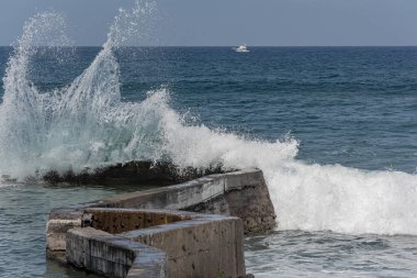 Deniz dalgaları kıyıdaki bir rıhtıma vuruyor. Stok fotoğrafı