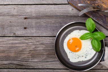 Kopya alanı ile ahşap tabloda Fesleğenli kızarmış yumurta. Closeup üstten görünüm