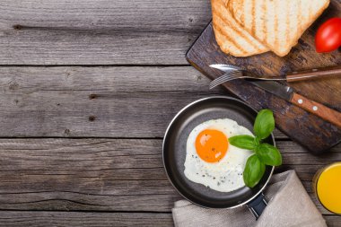Kopya alanı ile ahşap tabloda Fesleğenli kızarmış yumurta. Üstten görünüm