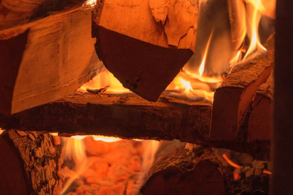 Une pile de bois de chauffage brûle dans le four . — Photo