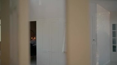Duvarda asılı duran zarif beyaz gelinlik, cam kapılardan çekilen. Düğün hazırlıklarının ve düğün hazırlıklarının atmosferik çekimi.