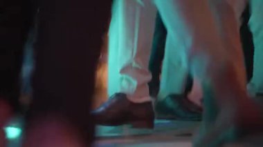 Close up view of mens feet dancing on stage in low light, Movement, rhythm and nightlife atmosphere.