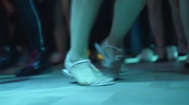 Close up slow motion of female feet moving on dance floor, Nightlife, rhythm, energy and celebration atmosphere.