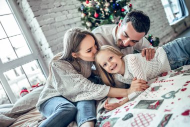 Üç yatakta Noel ağacı önünde sarılma bir aile. Yeni yıl arifesi. Köknar ağacı rahat tatil. aşk, mutluluk ve büyük aile kavramı
