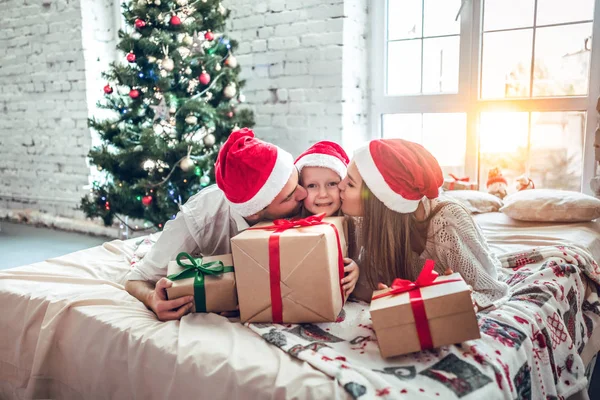 Boldog Szülők Csók Lánya Amely Xmas Jelen Ágyon Karácsonyfa Háttér — Stock Fotó